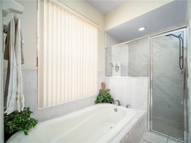 bathroom with tile patterned floors and shower with separate bathtub