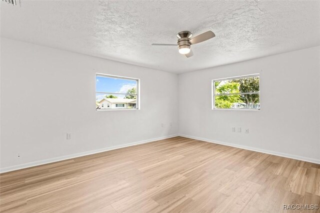 33 New York Blvd, Beverly Hills, FL 34465 - empty room with light wood-style flooring, a ceiling fan, and a textured ceiling