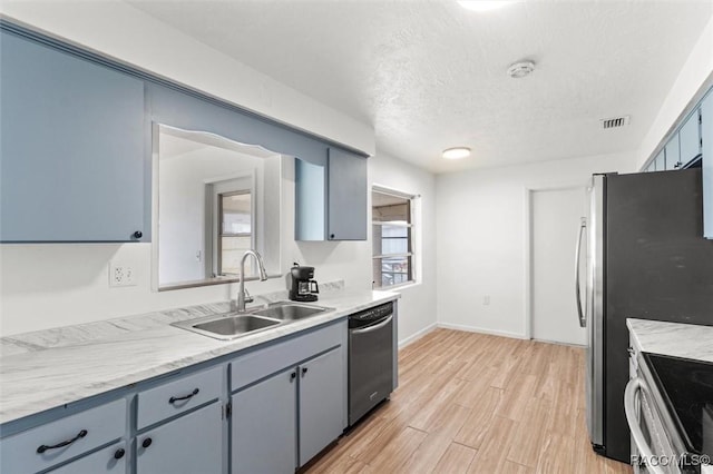 33 New York Blvd, Beverly Hills, FL 34465 - kitchen featuring appliances with stainless steel finishes, light countertops, light wood-style flooring, a textured ceiling, and gray cabinets