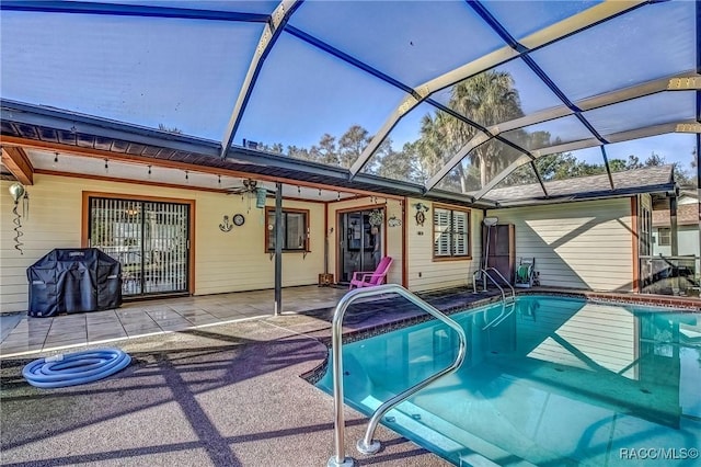 view of swimming pool with glass enclosure and a patio