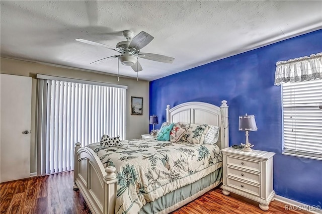 bedroom with hardwood / wood-style floors, ceiling fan, and a textured ceiling