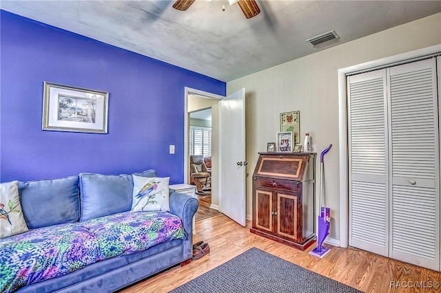 living room featuring light wood-type flooring and ceiling fan