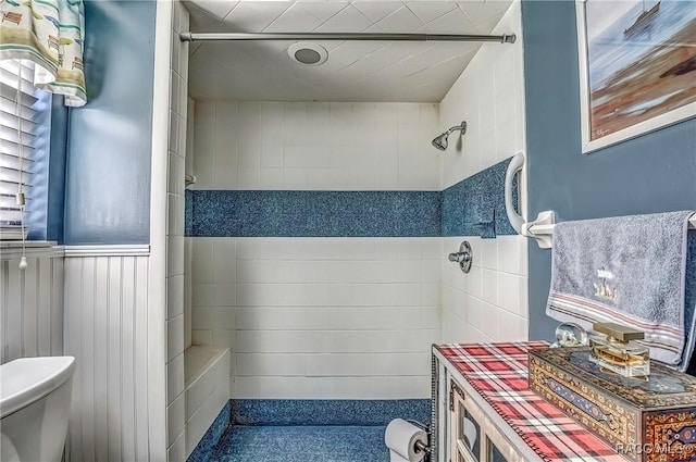 bathroom featuring a tile shower and toilet