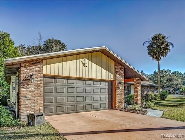 view of front of home with central air condition unit and a garage