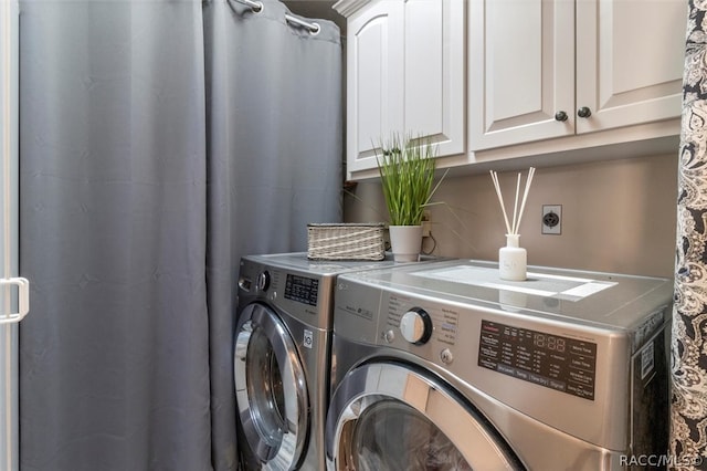 washroom featuring washer and clothes dryer and cabinets