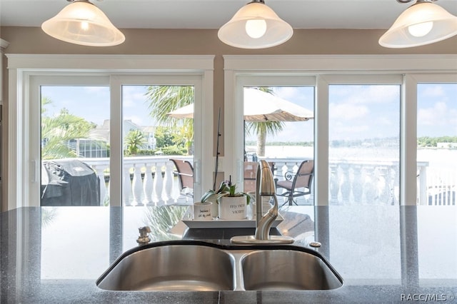 kitchen with pendant lighting, sink, and stone counters