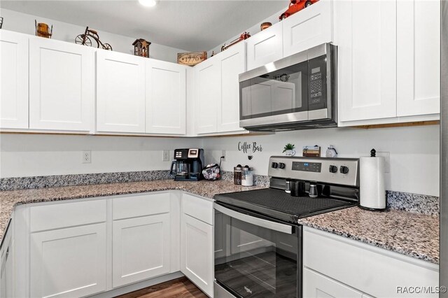 3192 W Barberton Pl, Citrus Springs, FL 34434 - kitchen featuring stainless steel appliances, white cabinets, light stone countertops, and wood finished floors