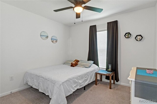 3192 W Barberton Pl, Citrus Springs, FL 34434 - bedroom with light carpet, baseboards, and a ceiling fan