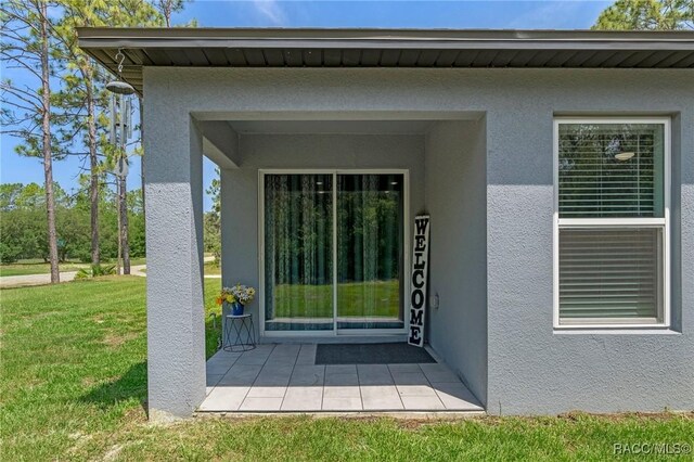 3192 W Barberton Pl, Citrus Springs, FL 34434 - entrance to property featuring stucco siding and a yard
