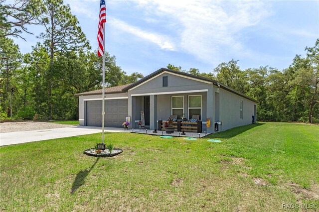 3192 W Barberton Pl, Citrus Springs, FL 34434 - view of front of house featuring covered porch, a garage, driveway, and a front yard