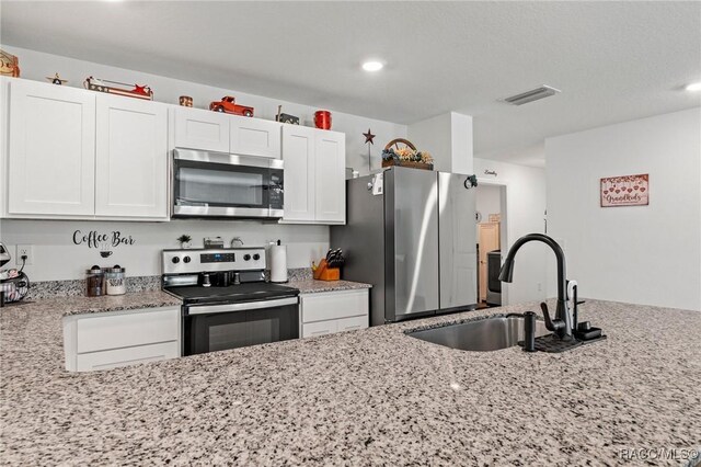 3192 W Barberton Pl, Citrus Springs, FL 34434 - kitchen with stainless steel appliances, a sink, white cabinets, light stone countertops, and recessed lighting