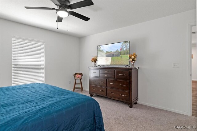 3192 W Barberton Pl, Citrus Springs, FL 34434 - bedroom with multiple windows, baseboards, light colored carpet, and a ceiling fan
