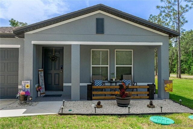 3192 W Barberton Pl, Citrus Springs, FL 34434 - view of front of house with a porch, a garage, and stucco siding