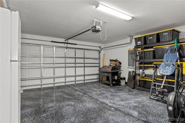 3192 W Barberton Pl, Citrus Springs, FL 34434 - garage featuring a garage door opener and freestanding refrigerator