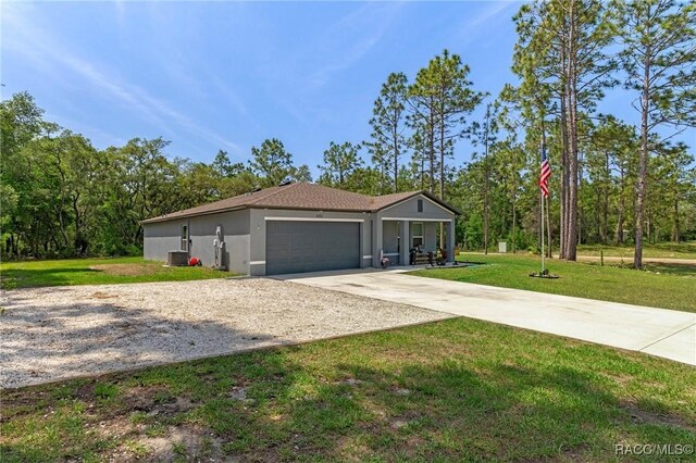 3192 W Barberton Pl, Citrus Springs, FL 34434 - view of front facade featuring concrete driveway, a garage, a front lawn, stucco siding, and central air condition unit