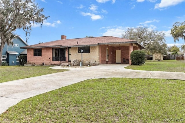 ranch-style house with driveway, brick siding, a chimney, and a front yard