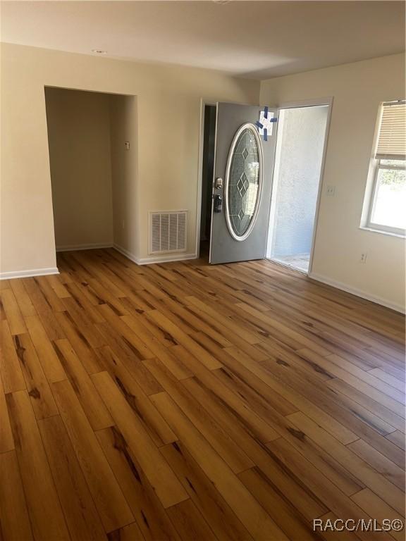 interior space with wood finished floors, visible vents, and baseboards