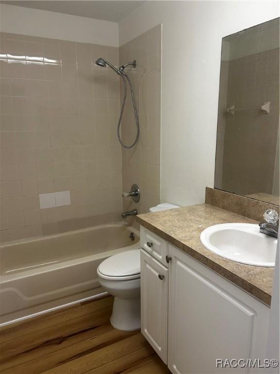 full bath featuring toilet, vanity, bathtub / shower combination, and wood finished floors