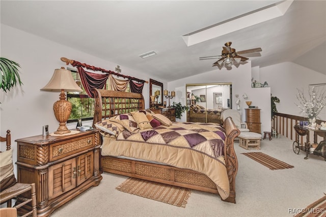 carpeted bedroom with lofted ceiling with skylight, visible vents, and a ceiling fan