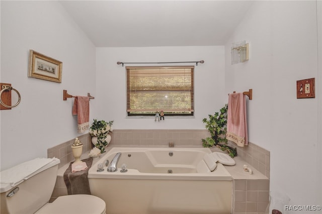 full bathroom featuring toilet, lofted ceiling, and a whirlpool tub