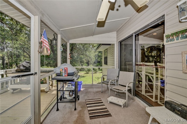 sunroom featuring vaulted ceiling and a ceiling fan