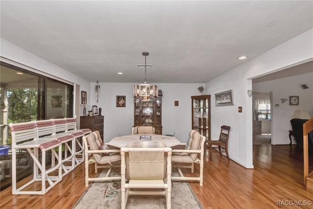 dining space featuring recessed lighting, light wood-type flooring, and an inviting chandelier