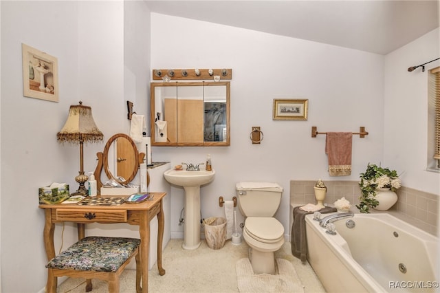 full bathroom featuring a whirlpool tub, toilet, and a sink