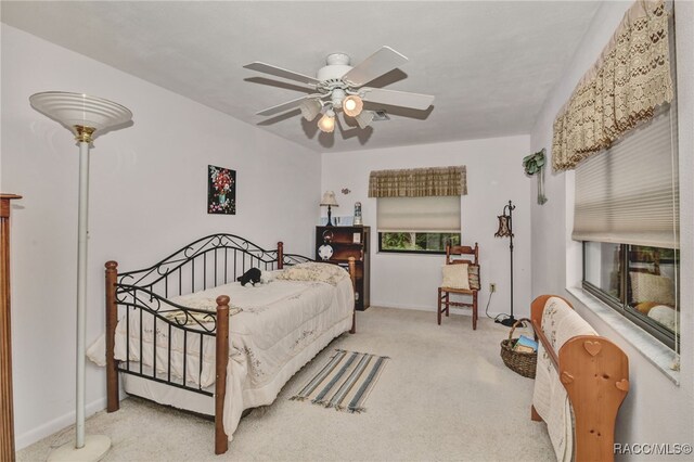 carpeted bedroom with ceiling fan and baseboards