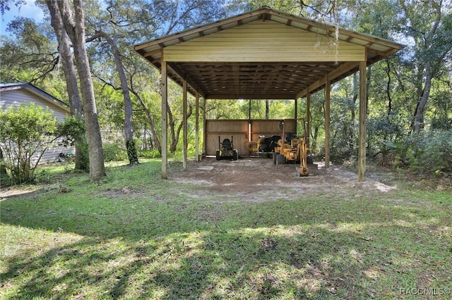 view of yard with a carport, an outbuilding, and driveway