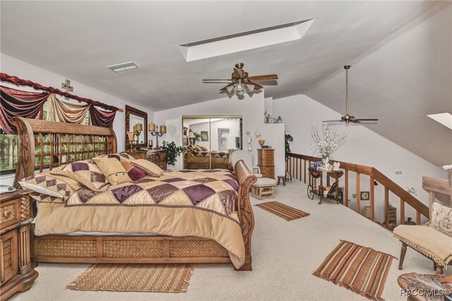 bedroom with carpet floors, vaulted ceiling with skylight, visible vents, and a ceiling fan