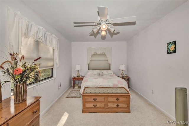 bedroom with a ceiling fan, light carpet, and baseboards