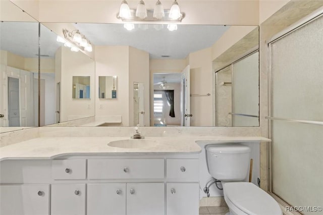 bathroom with vanity, toilet, and a shower with door