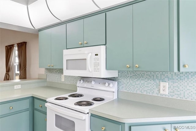 kitchen with blue cabinetry, tasteful backsplash, white appliances, a peninsula, and light countertops