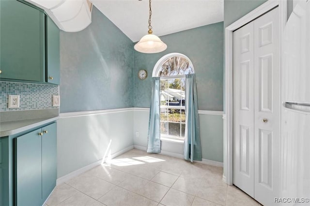 unfurnished dining area with light tile patterned flooring and baseboards