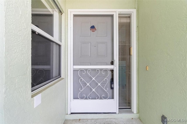 view of exterior entry featuring stucco siding