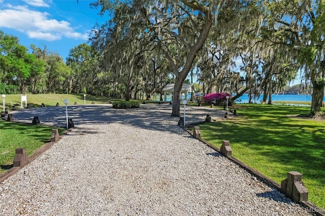 surrounding community with a yard and a water view