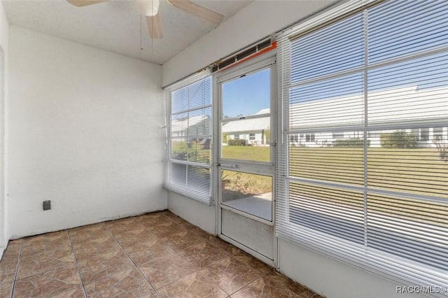 unfurnished sunroom with ceiling fan