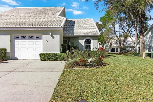 view of front of property with stucco siding, a front lawn, concrete driveway, a garage, and a tiled roof