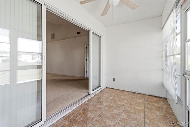 unfurnished sunroom featuring visible vents and ceiling fan