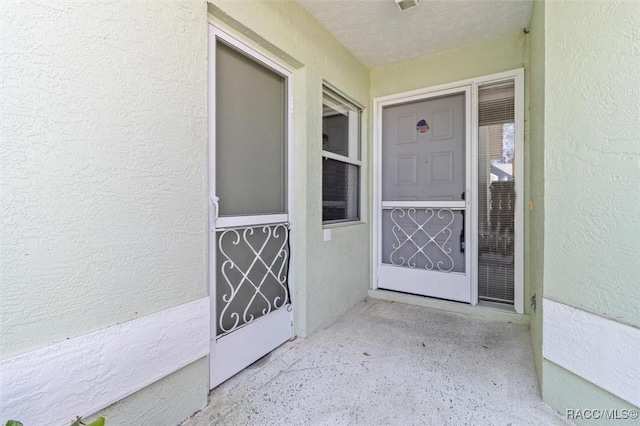 entrance to property featuring stucco siding