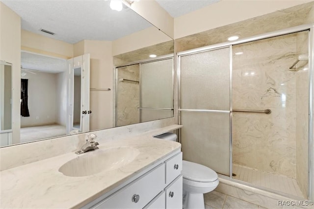 full bath featuring visible vents, toilet, a stall shower, a textured ceiling, and vanity