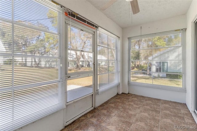 unfurnished sunroom featuring a ceiling fan