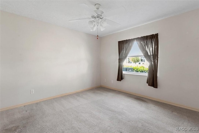 carpeted empty room featuring baseboards and ceiling fan