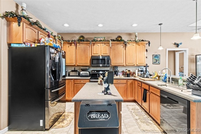 kitchen with tasteful backsplash, sink, black appliances, a kitchen island, and hanging light fixtures