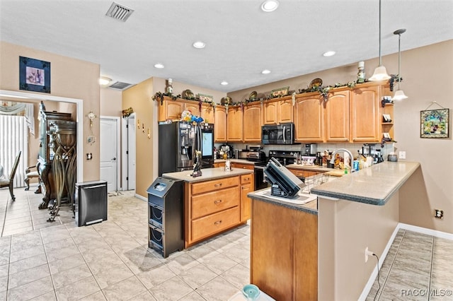 kitchen featuring sink, kitchen peninsula, pendant lighting, light tile patterned floors, and appliances with stainless steel finishes