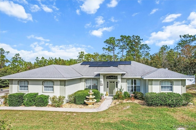 single story home featuring a front yard and solar panels