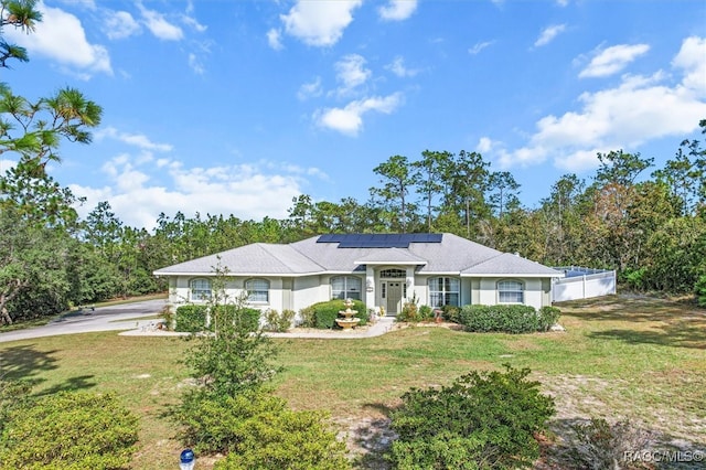 ranch-style house with a front lawn and solar panels