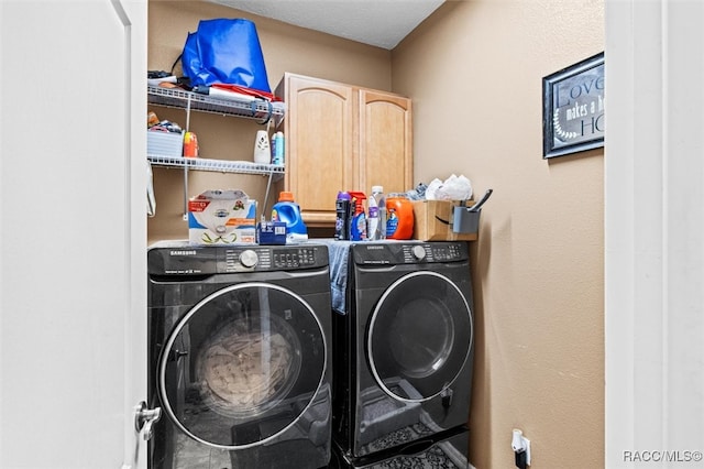 laundry area with cabinets, independent washer and dryer, and a textured ceiling