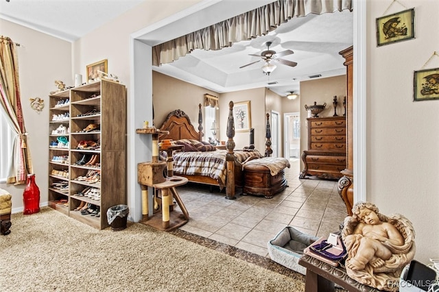 bedroom featuring tile patterned floors, ceiling fan, and a raised ceiling