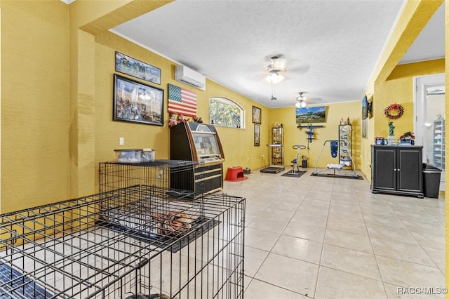 interior space featuring tile patterned flooring, a textured ceiling, an AC wall unit, and ceiling fan